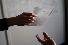 ręka podająca kartkę papieru